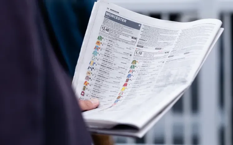 A race goer reading the racing post - full of statistics