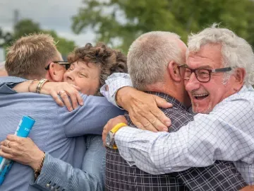 Four people hugging and celebrating at Worcester Racecourse