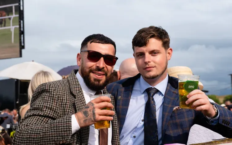 Two race goers at Worcester in suits pose for the camera