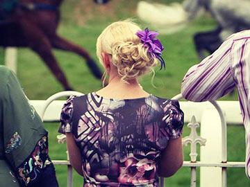 A dressed up woman at the races.