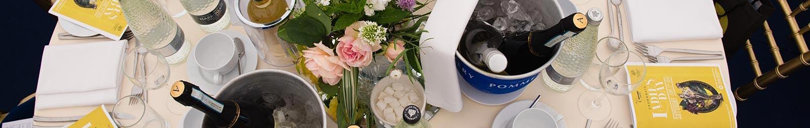 An overhead view of a table decorated in a wedding theme with bottles on ice.