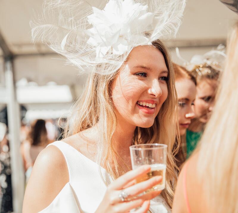 Lady in hat having a drink.