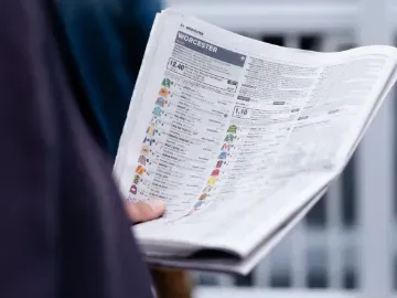 A race goer reading the racing post - full of statistics