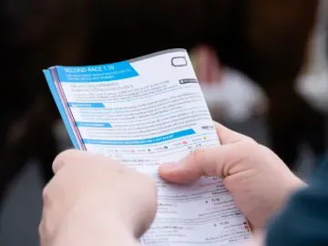 A racegoer reading the race card at Worcester Racecourse