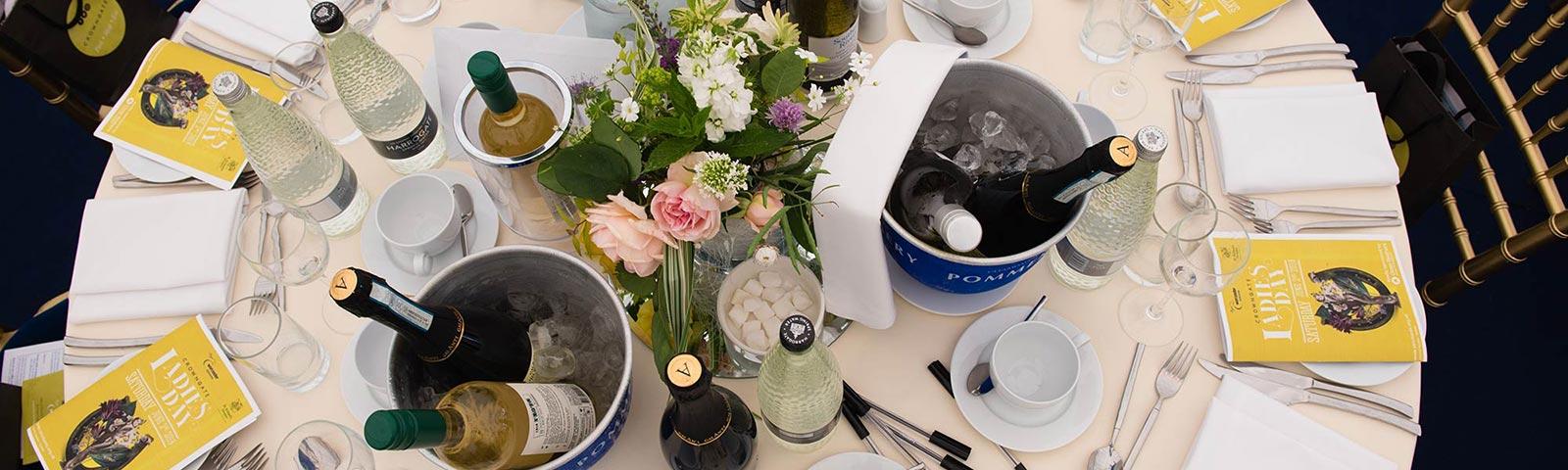Av overhead view of a table stocked with bottles of water and wine on ice.