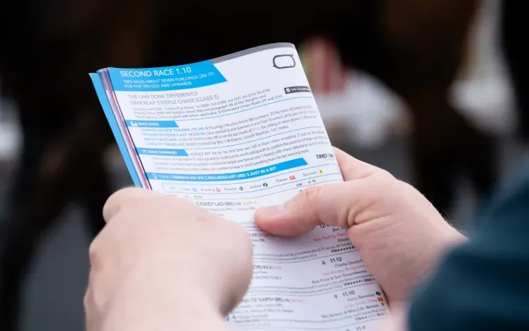 A racegoer reading the race card at Worcester Racecourse