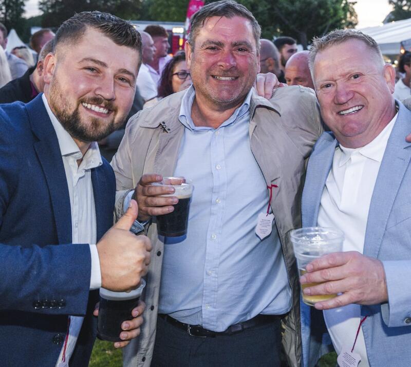 A trio of race goers smile for a pictures