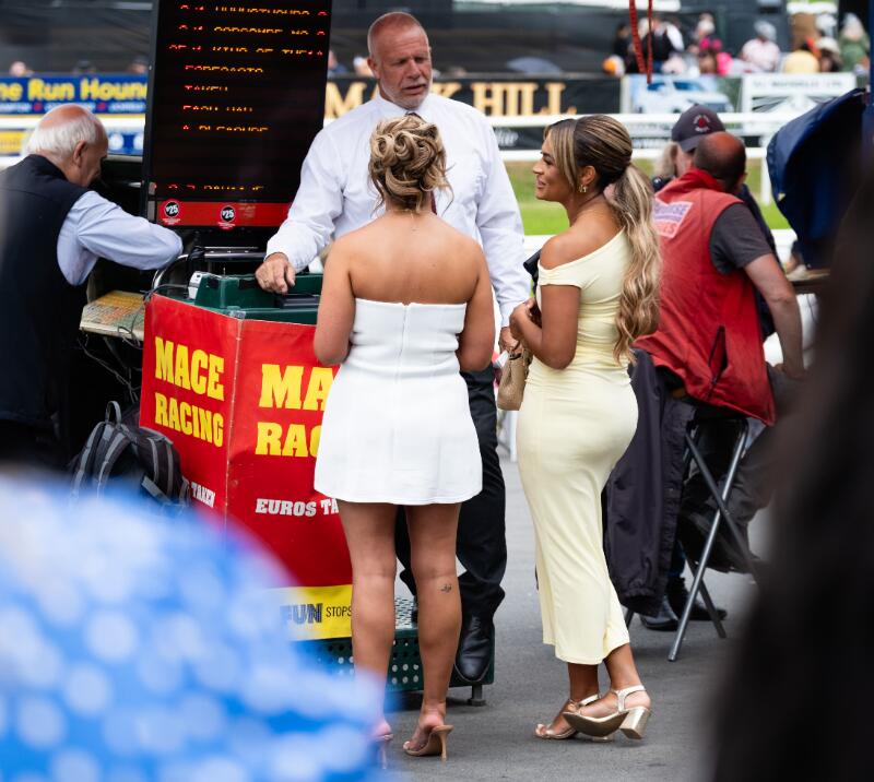 Two race goers placing a bet with a bookmakers at Worcester
